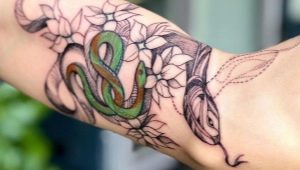 Examen du tatouage pour hommes avec des serpents sur le bras