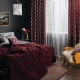 Burgundy curtains in the bedroom interior